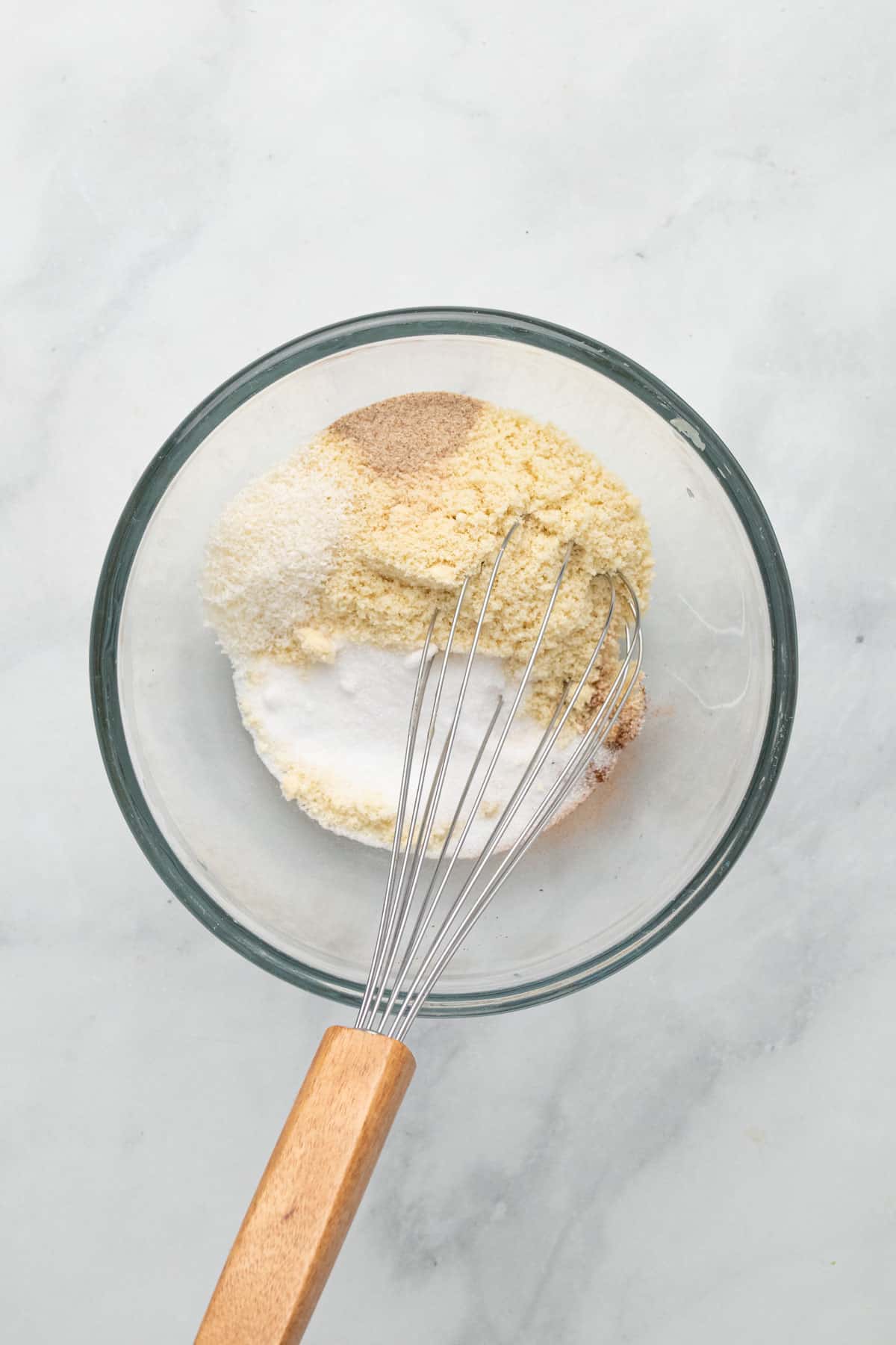 Dry ingredients in a glass mixing bowl with a whisk