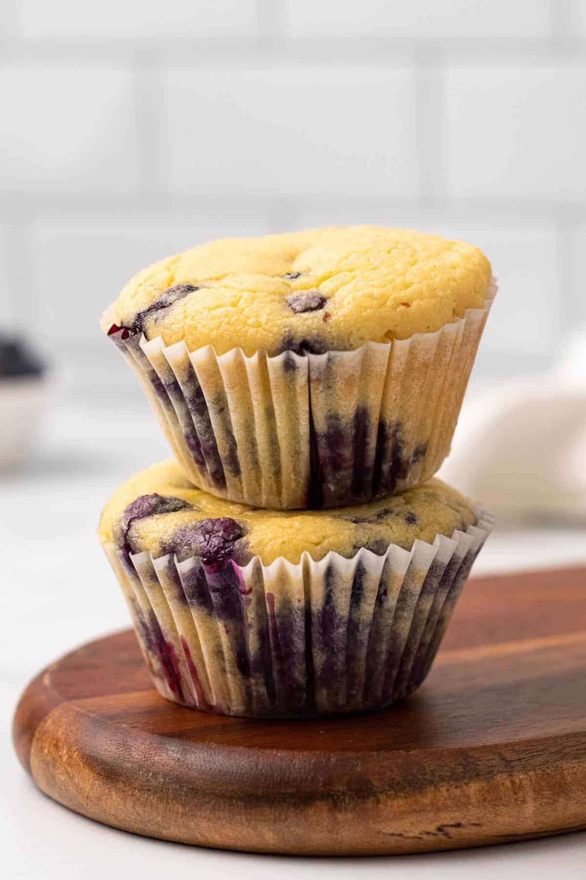 Stack of two Blueberry Muffins (with Coconut Oil) on a wooden cutting board