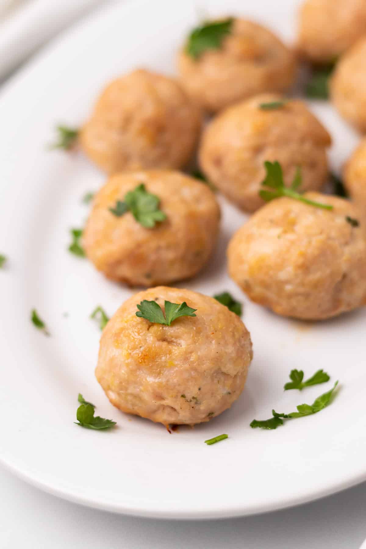 Close-up of chicken meatballs on a white serving platter