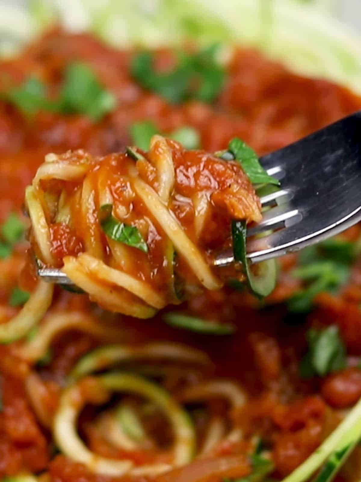 Marinara Sauce with Red Lentils served over zoodles with one bite on a fork over the plate
