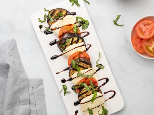 Caprese salad with eggplant on a white serving dish, as seen from above