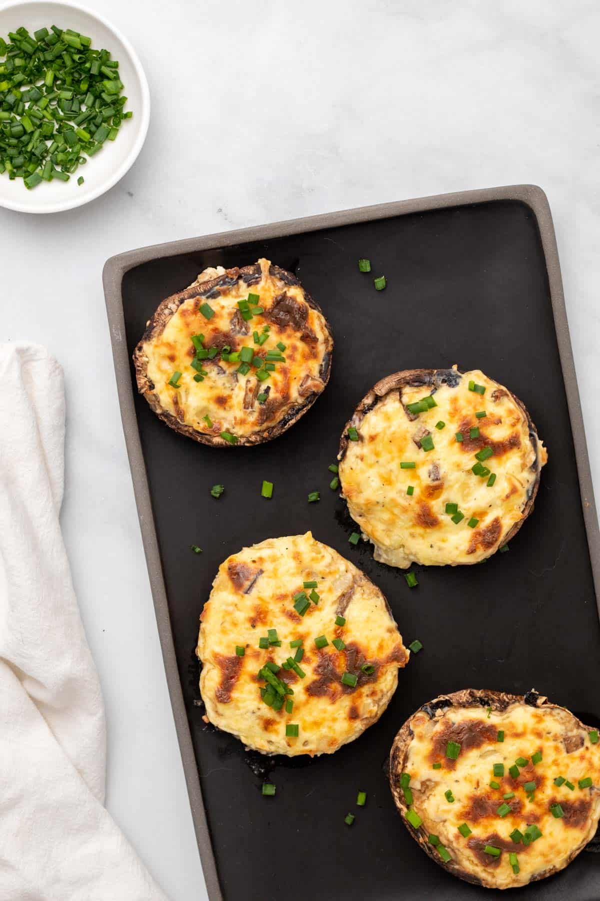 Mushrooms stuffed with cheese and garnished with chives, as seen from above