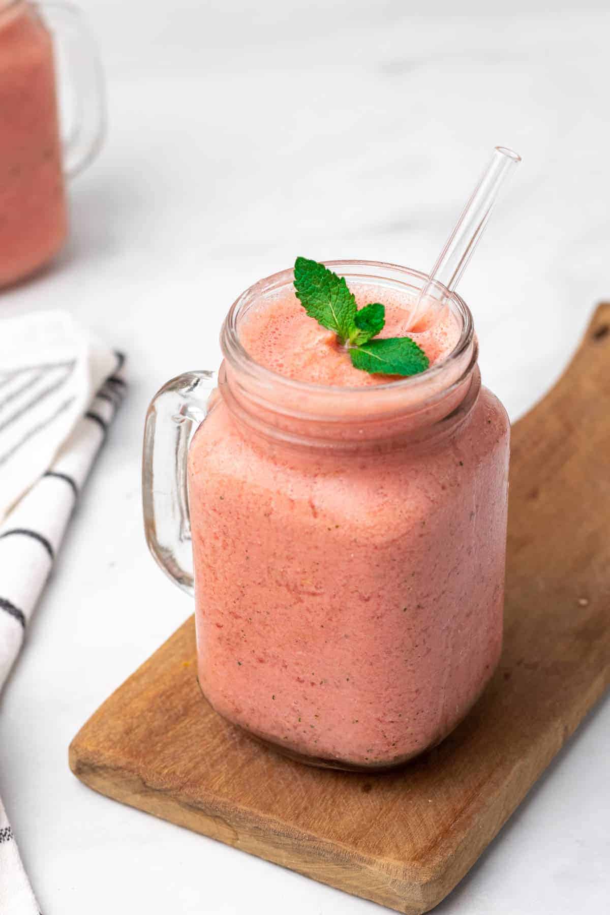 Smoothie in a glass jar garnished with fresh mint