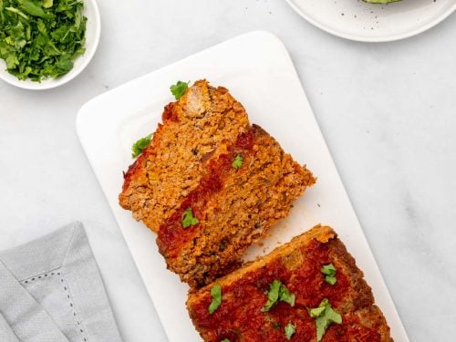 Taco meatloaf on a white serving platter with two slices cut from the loaf