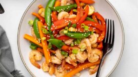 Keto shrimp stir fry in a white bowl with a spoon