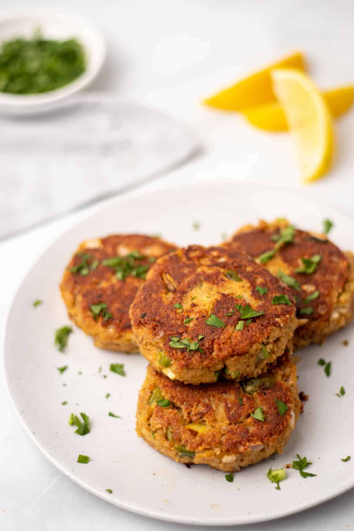 Four Low-Carb Crab Cakes on a white plate garnished with chopped parsley