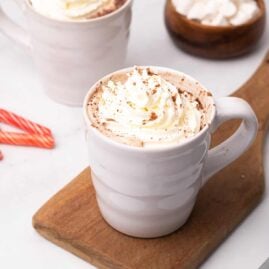 Skinny peppermint mocha latte topped with whipped cream on a wooden serving board
