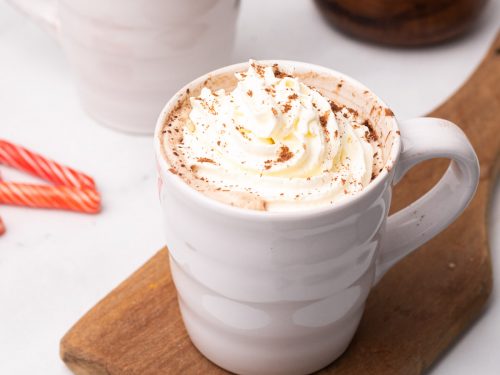 Skinny peppermint mocha latte topped with whipped cream on a wooden serving board