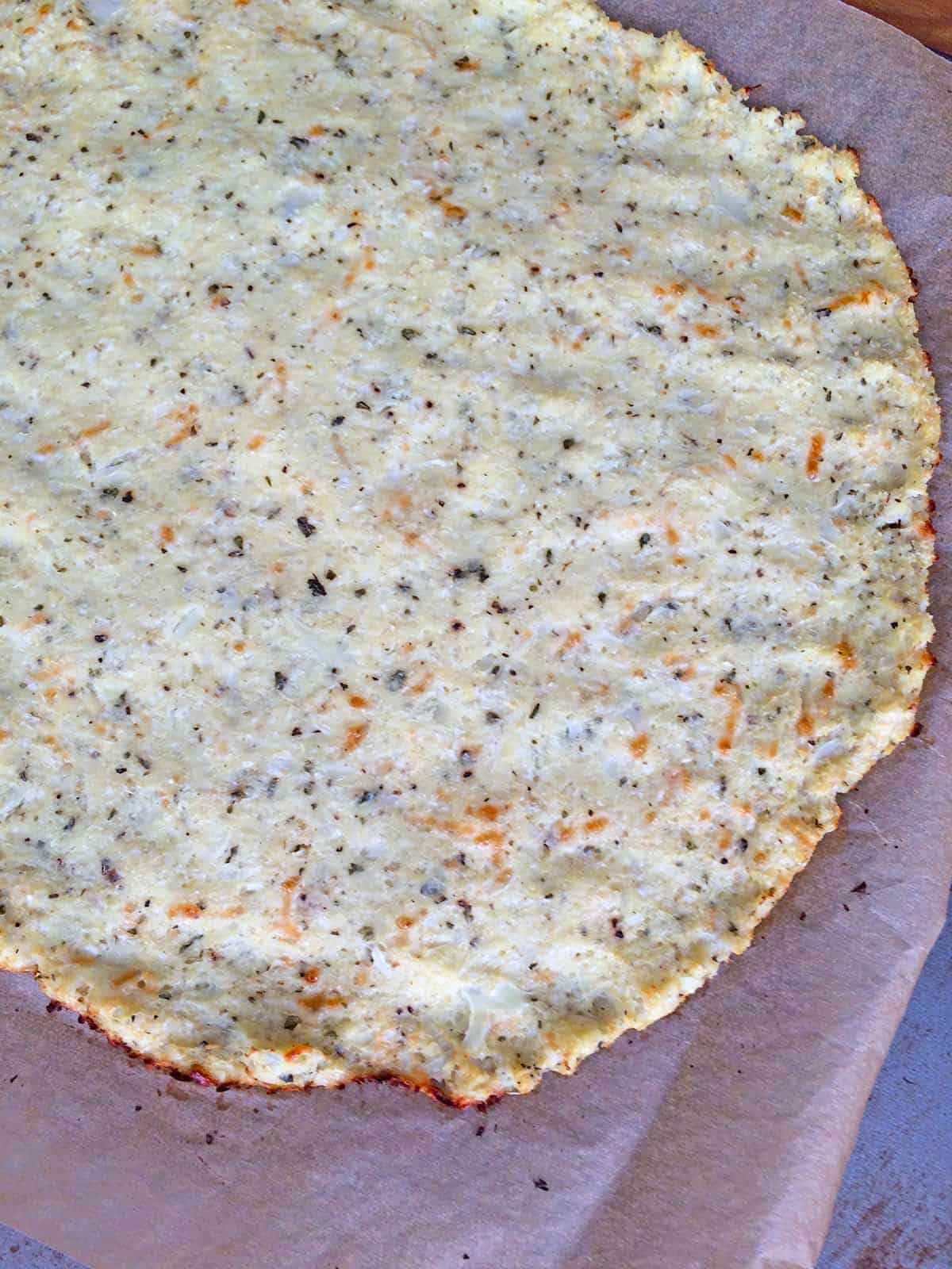 Baked cauliflower crust on parchment paper