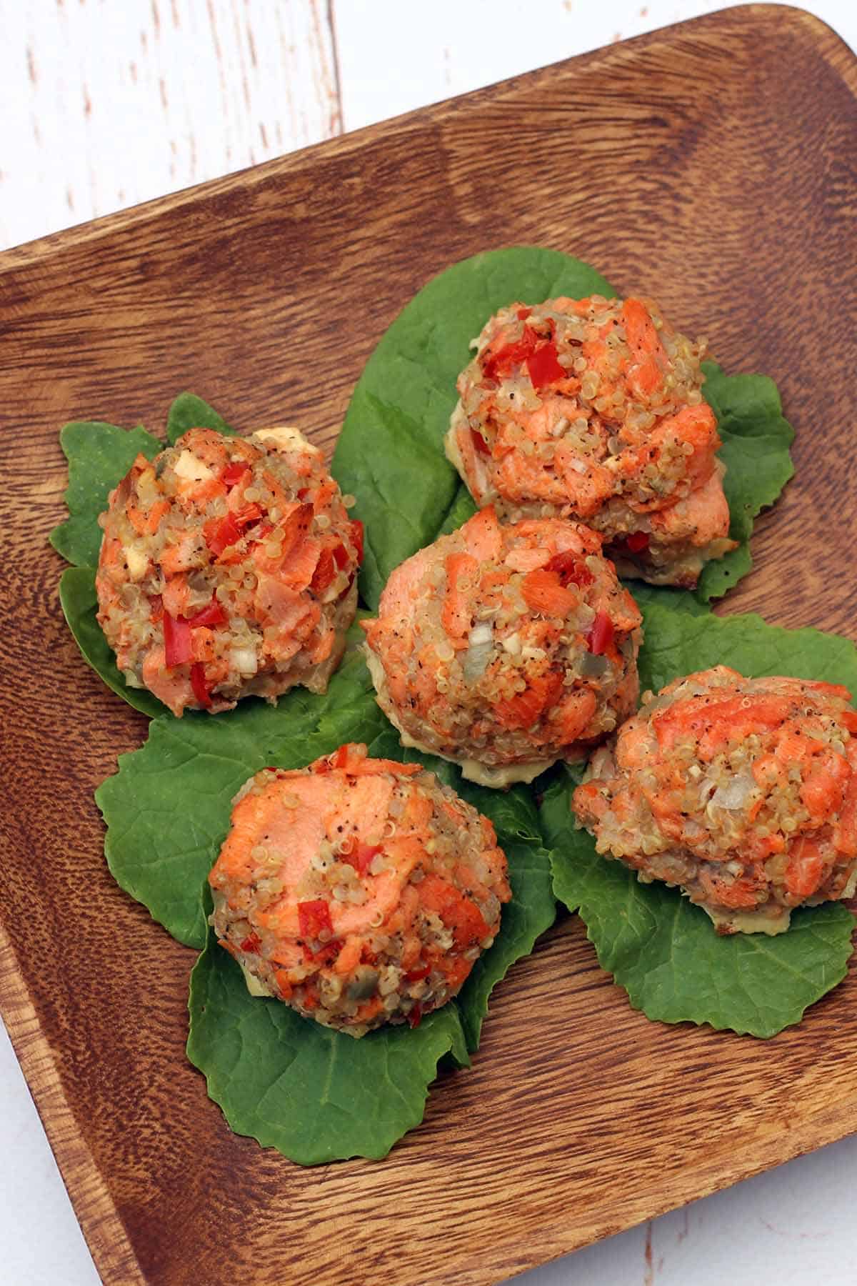 Salmon Meatballs with Quinoa on a wooden plate with leaves under each meatball