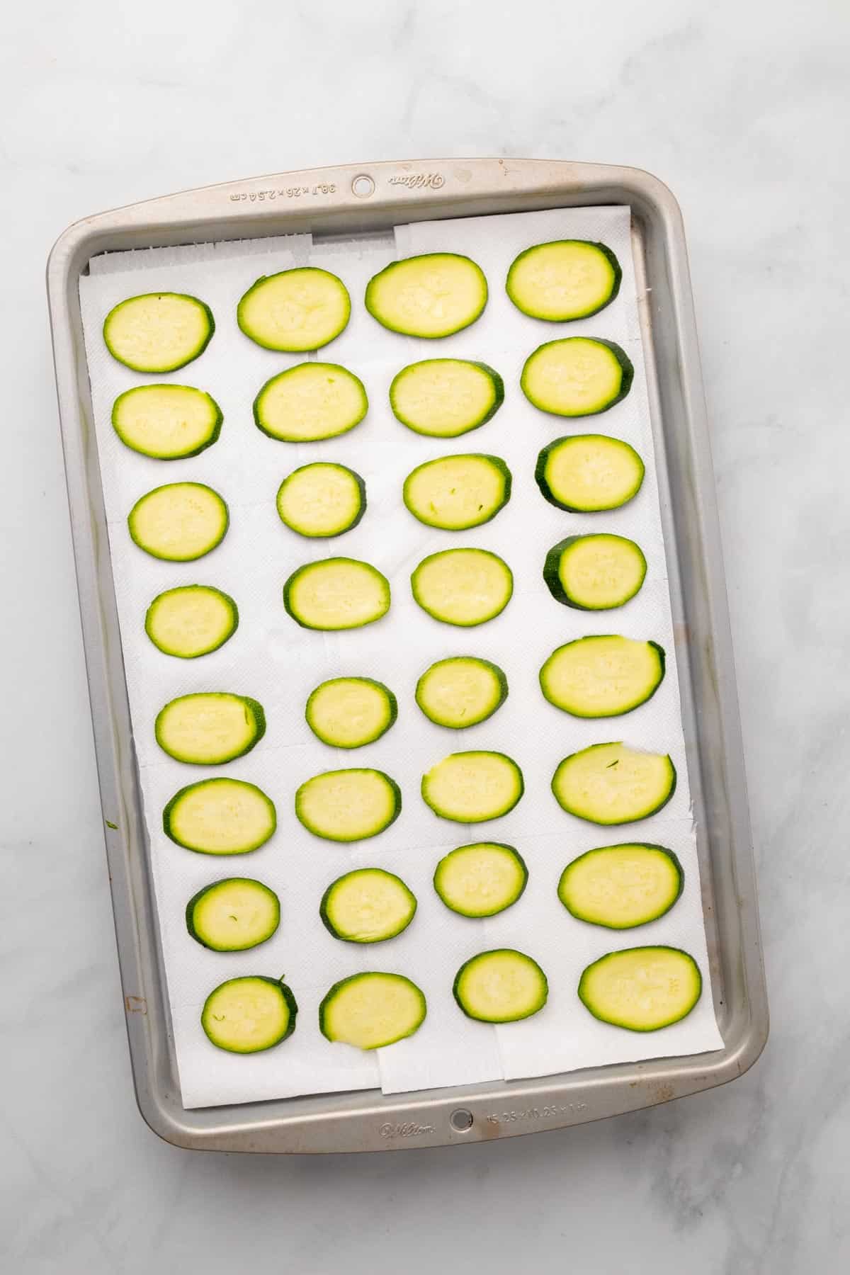 Salted zucchini slices on paper towels