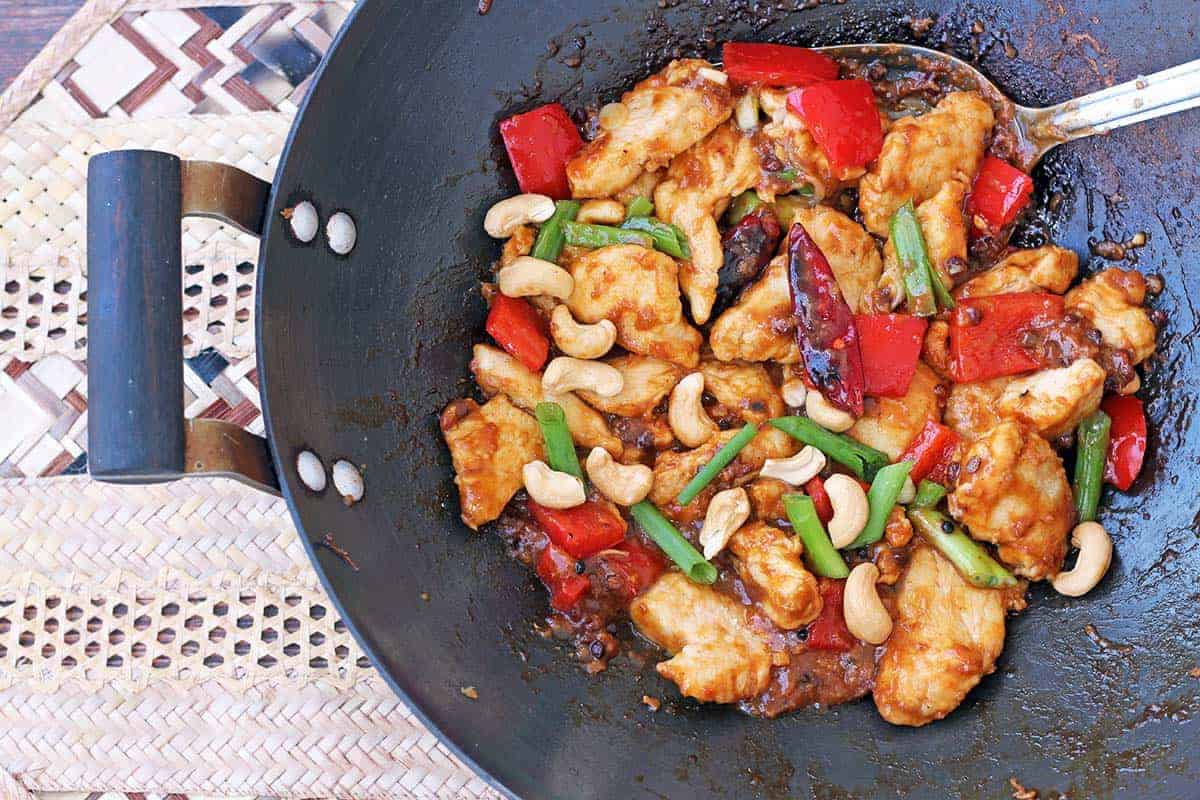 Kung Pao dish with chicken, chilis, green onion, and cashews in a wok