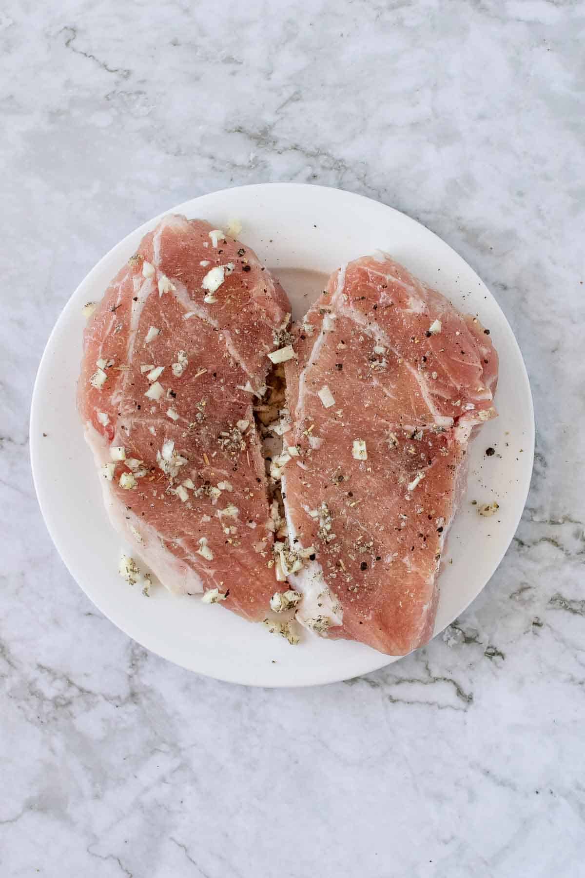 Two pork chops rubber with garlic and spices
