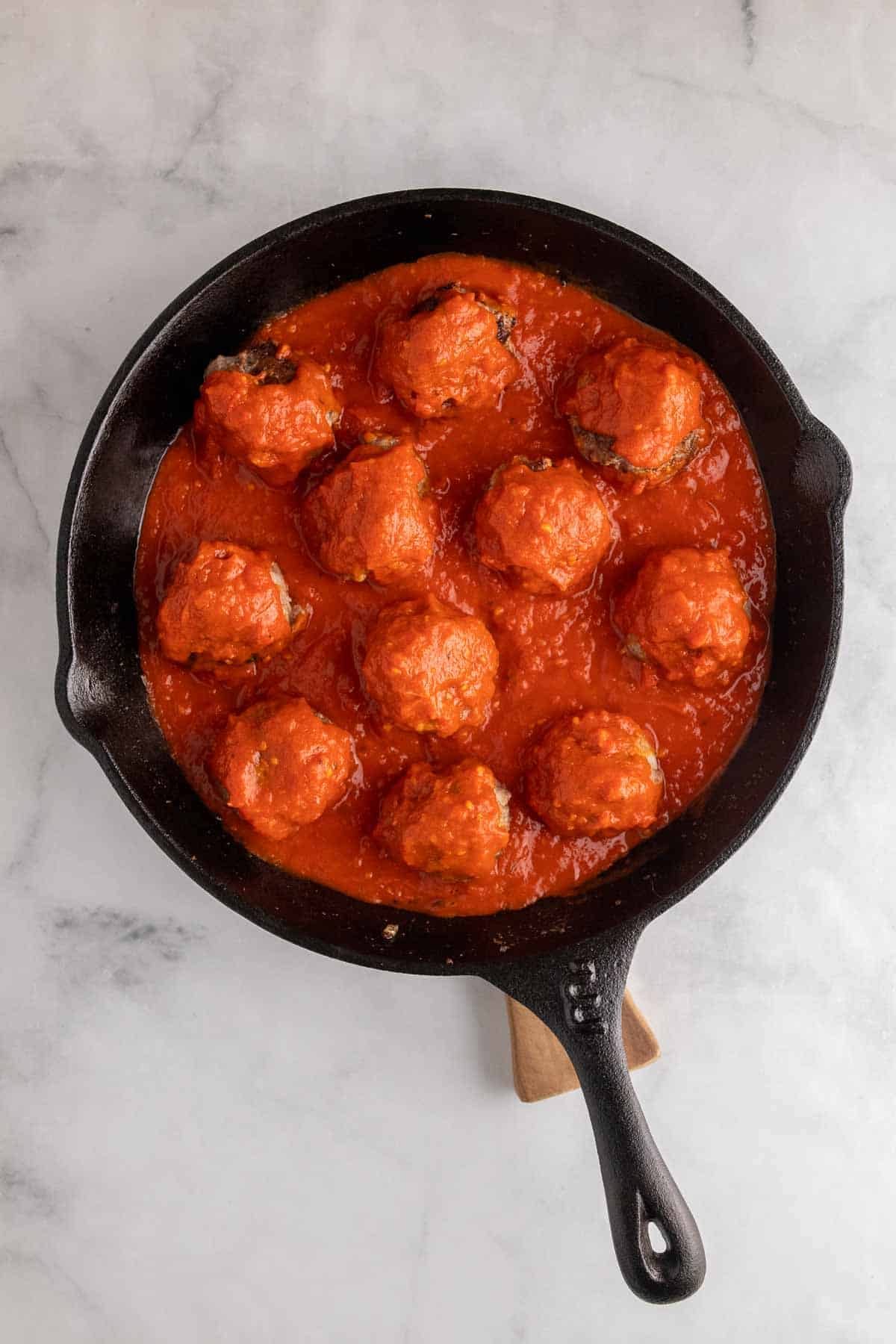 Meatballs in skillet with marinara sauce, as seen from above