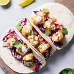 3 Low-Carb Buffalo Cauliflower Tacos on a wooden board