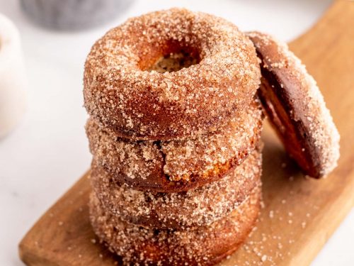 A stack of 4 cinnamon and sugar Keto donuts with a 5th donut leaning against the stack