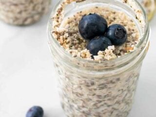 Keto overnight oats in a mason jar with three blueberries on top