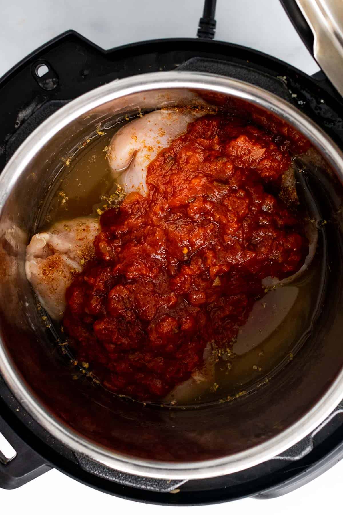 Salsa poured over the chicken breasts in the Instant Pot