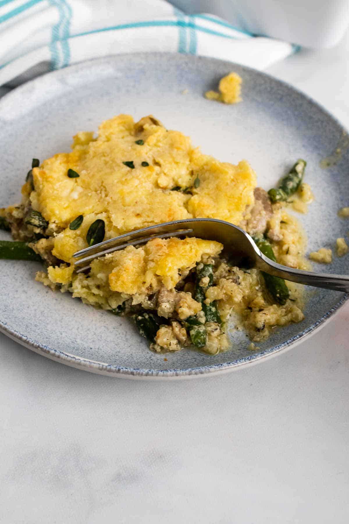 Keto chicken pot pie on a speckled plate with a fork cutting into a corner