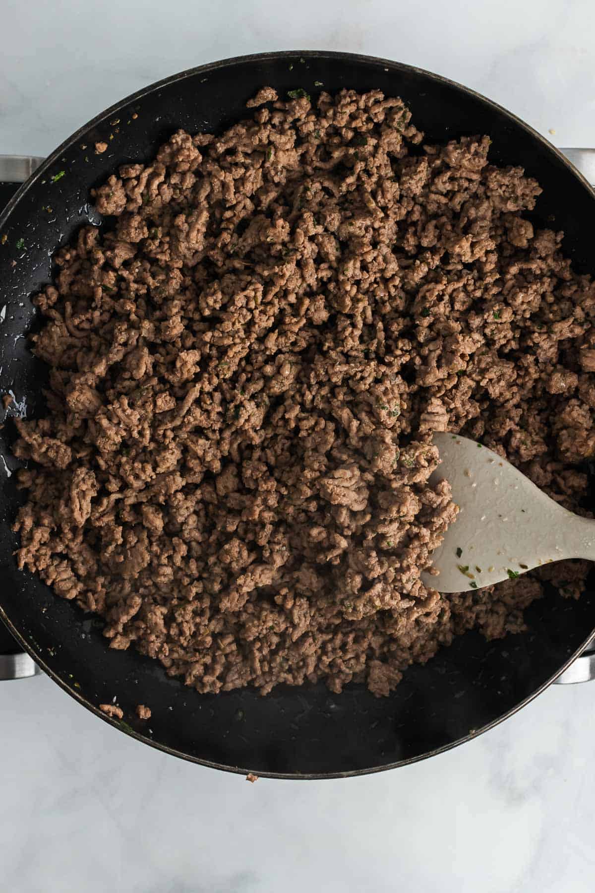 Cooked ground beef in a skillet, as seen from above