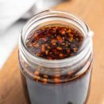 Teriyaki sauce in a glass mason jar on a wooden serving tray