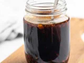 Sugar free teriyaki sauce in a glass mason jar with a metal spoon