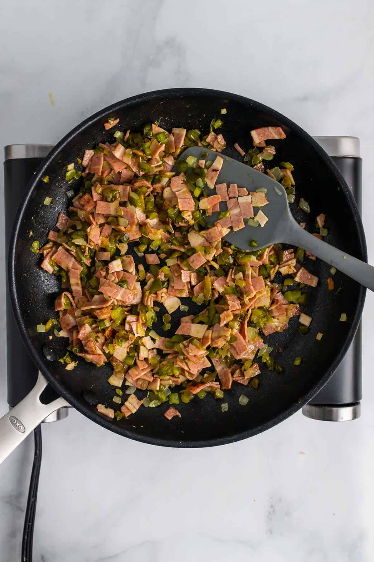 Cooked bacon and veggies in a pan