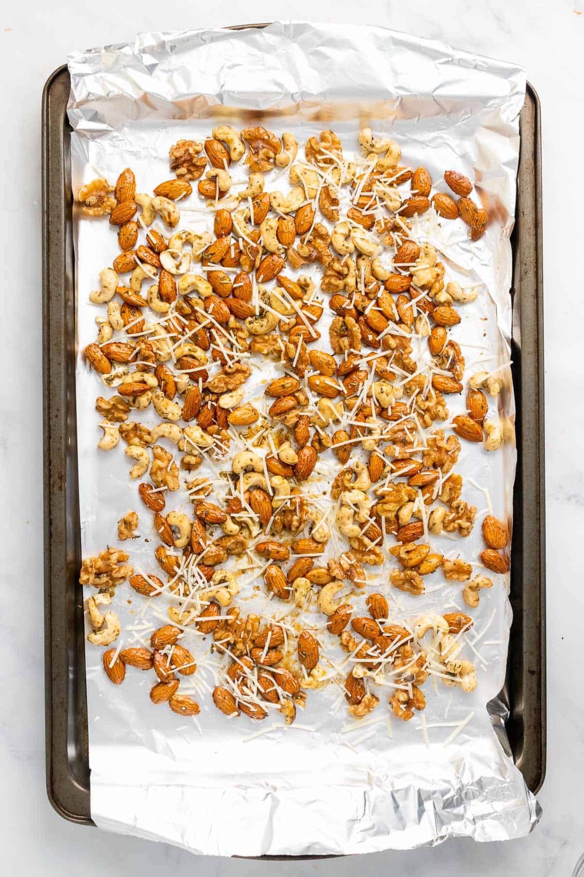Nuts with spices and cheese on baking tray