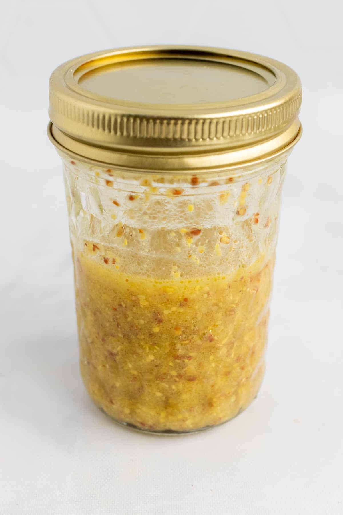 Mixed vinaigrette in a glass jar with screw-on lid 