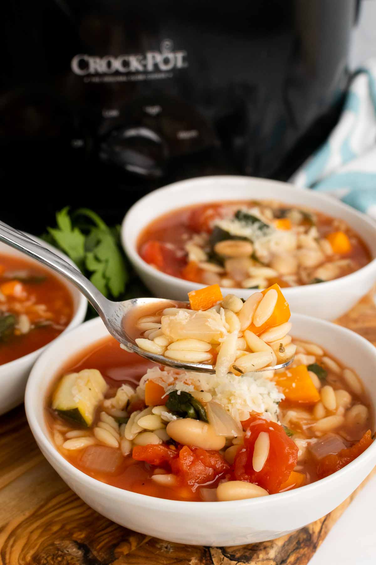 Spoon full of Slow Cooker Minestrone held over a bowl