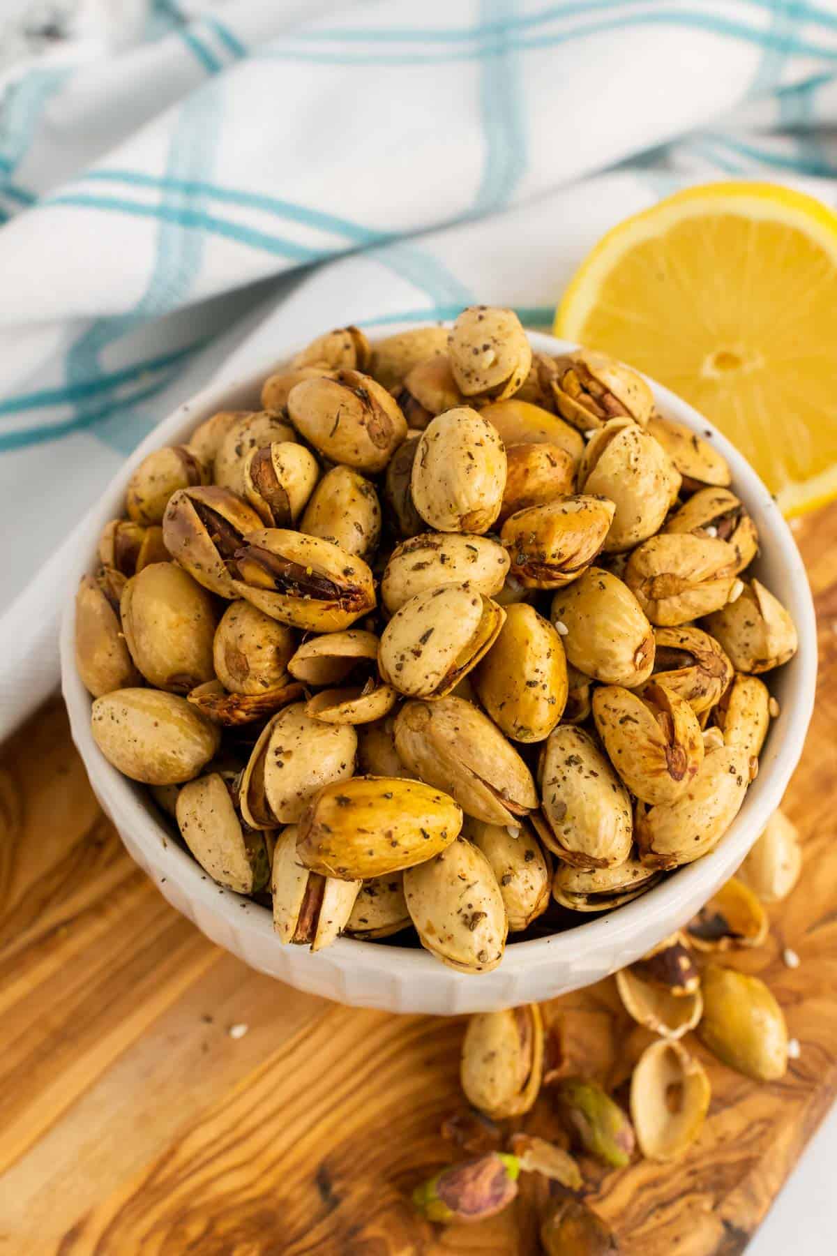 Bowl of pistachios on table with half a lemon