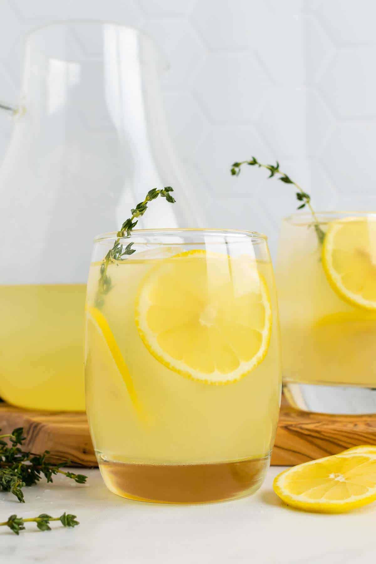 Two glasses of lemonade in front of pitcher