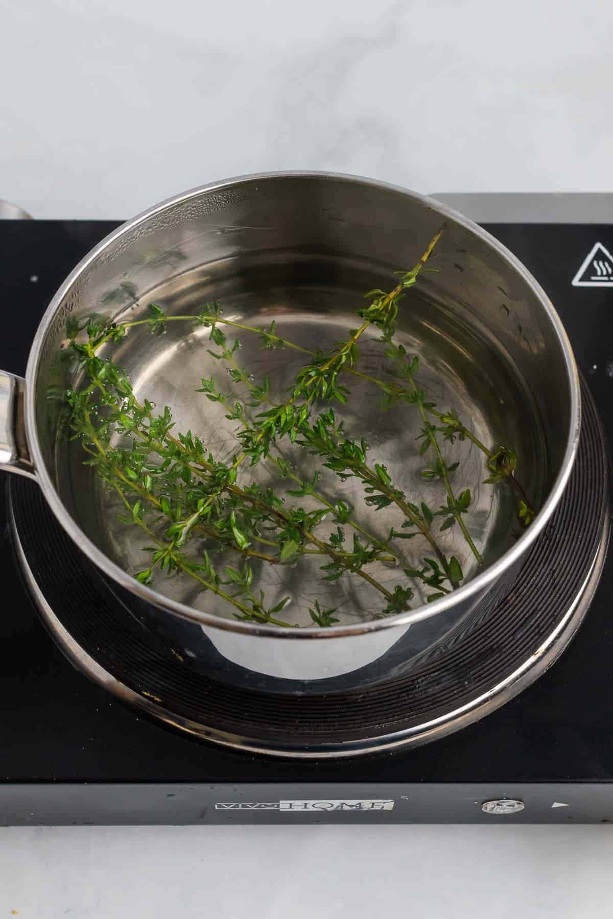 Thyme sprigs and lemonade in pot 