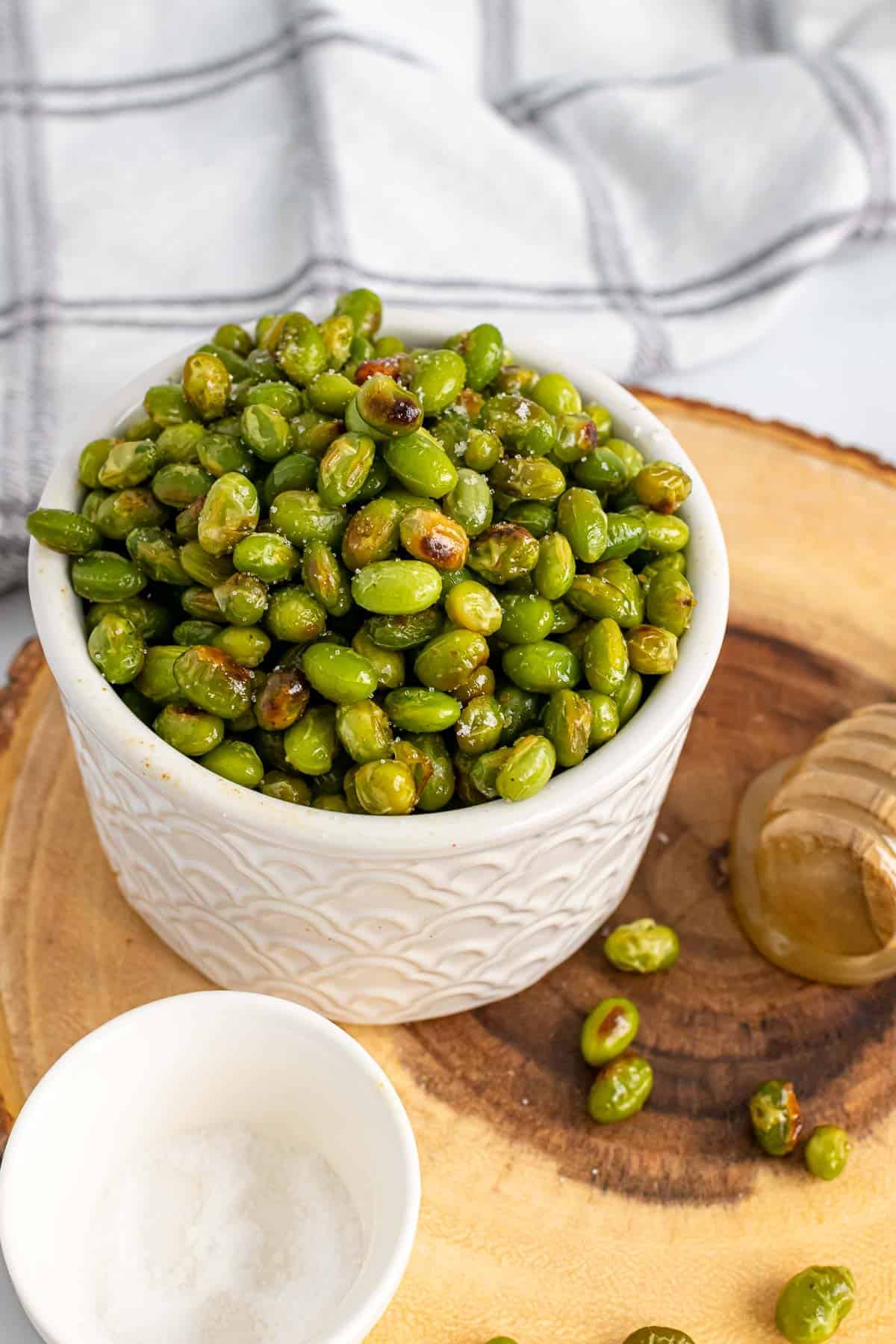 Roasted Edamame with Wasabi and Honey in a white bowl on table