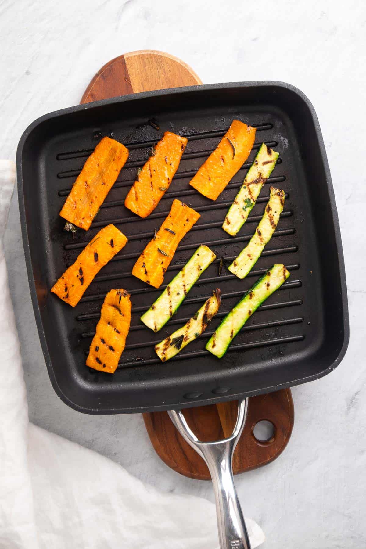 Sliced veggies on the grill pan with visible grill marks, as seen from above