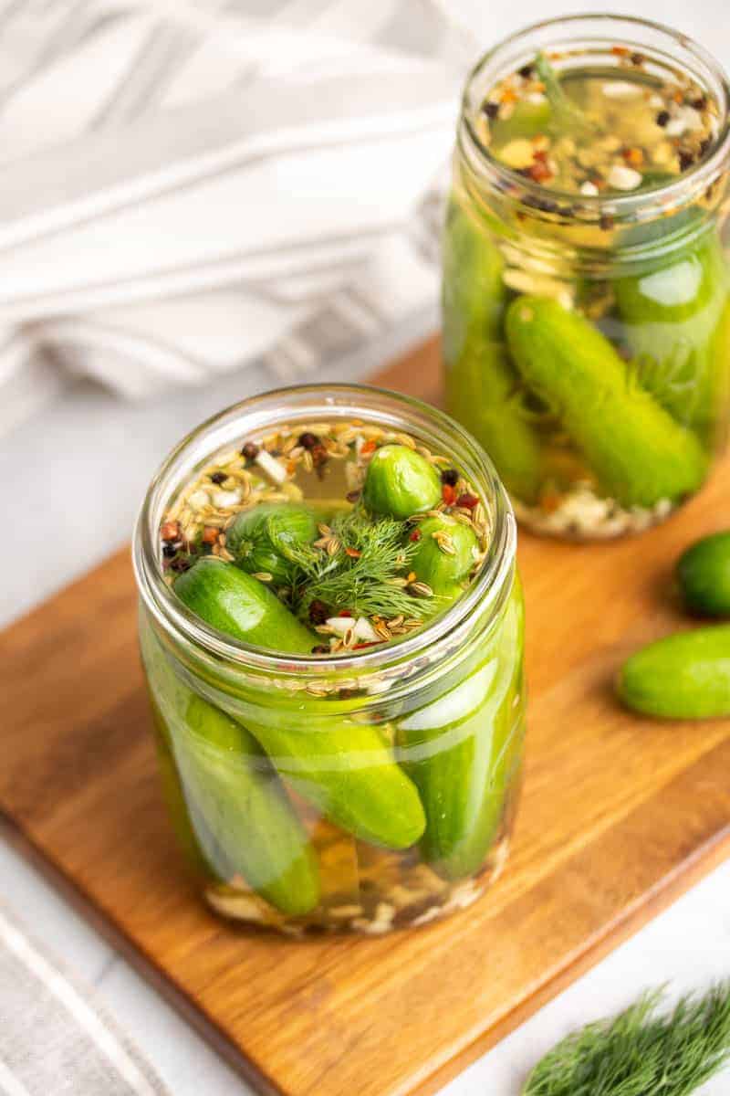 Low-Sodium pickles recipe separated into two glass jars on a wooden serving tray