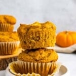 Two pumpkin pineapple muffins stacked on top of each other on a small white plate