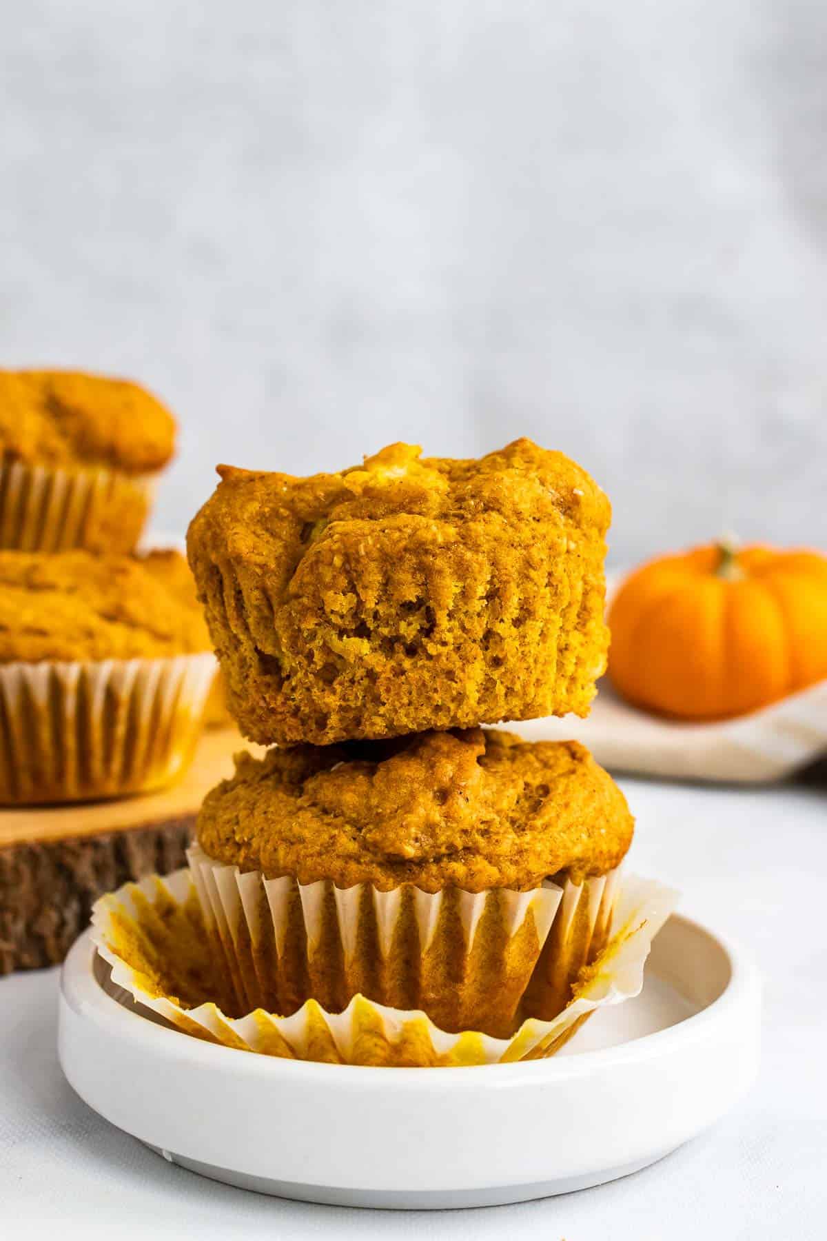 Two pumpkin pineapple muffins stacked on top of each other on a small white plate
