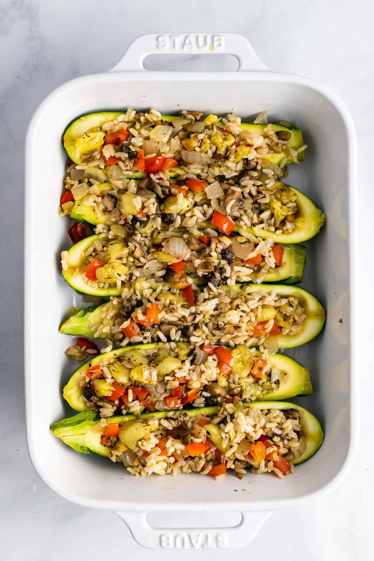 Zucchini shells in the casserole pan with the stuffing added