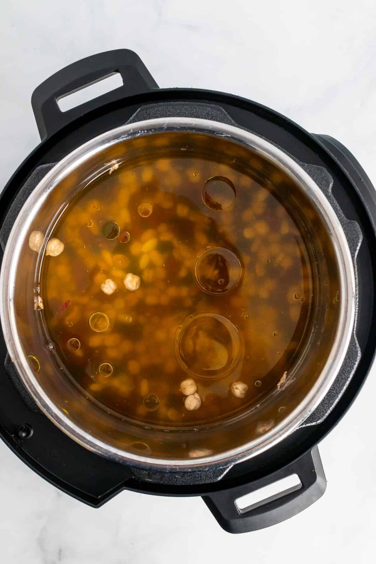 Beans, broth, and olive oil in a pressure cooker