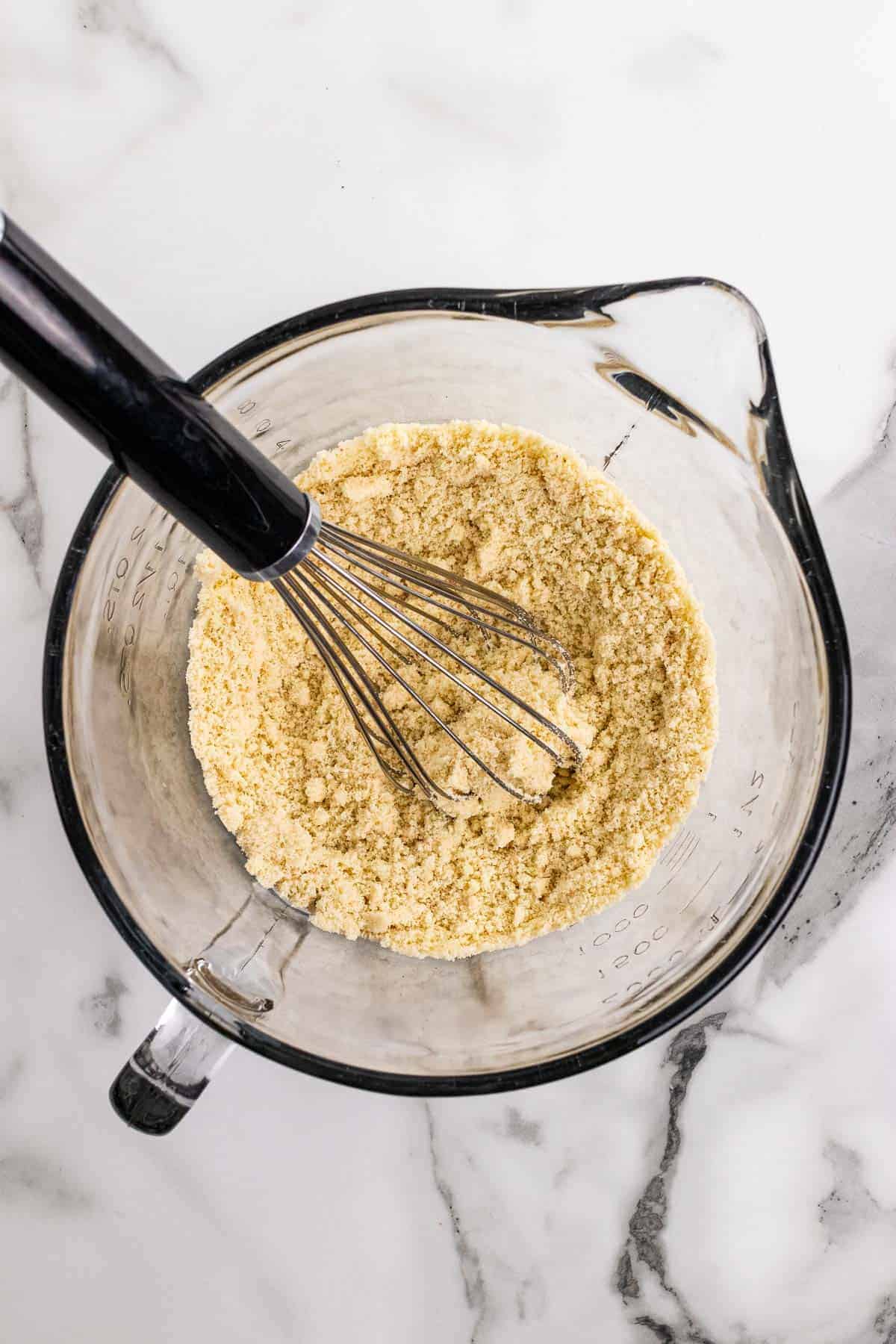 Dry ingredients mixed together in a glass measuring cup with a whisk, as seen from above