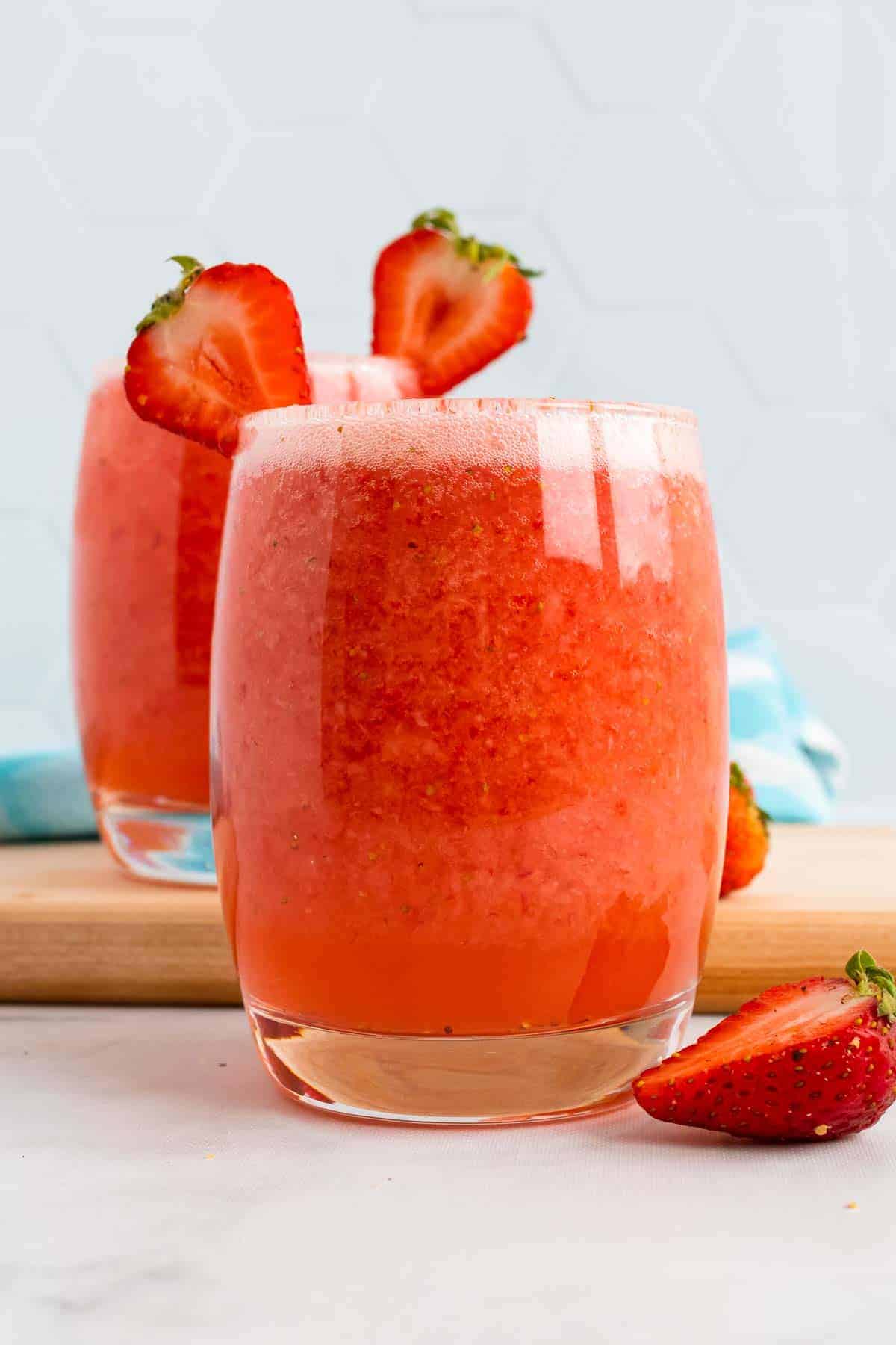 Two glasses of Strawberry Agua Fresca with fresh strawberries