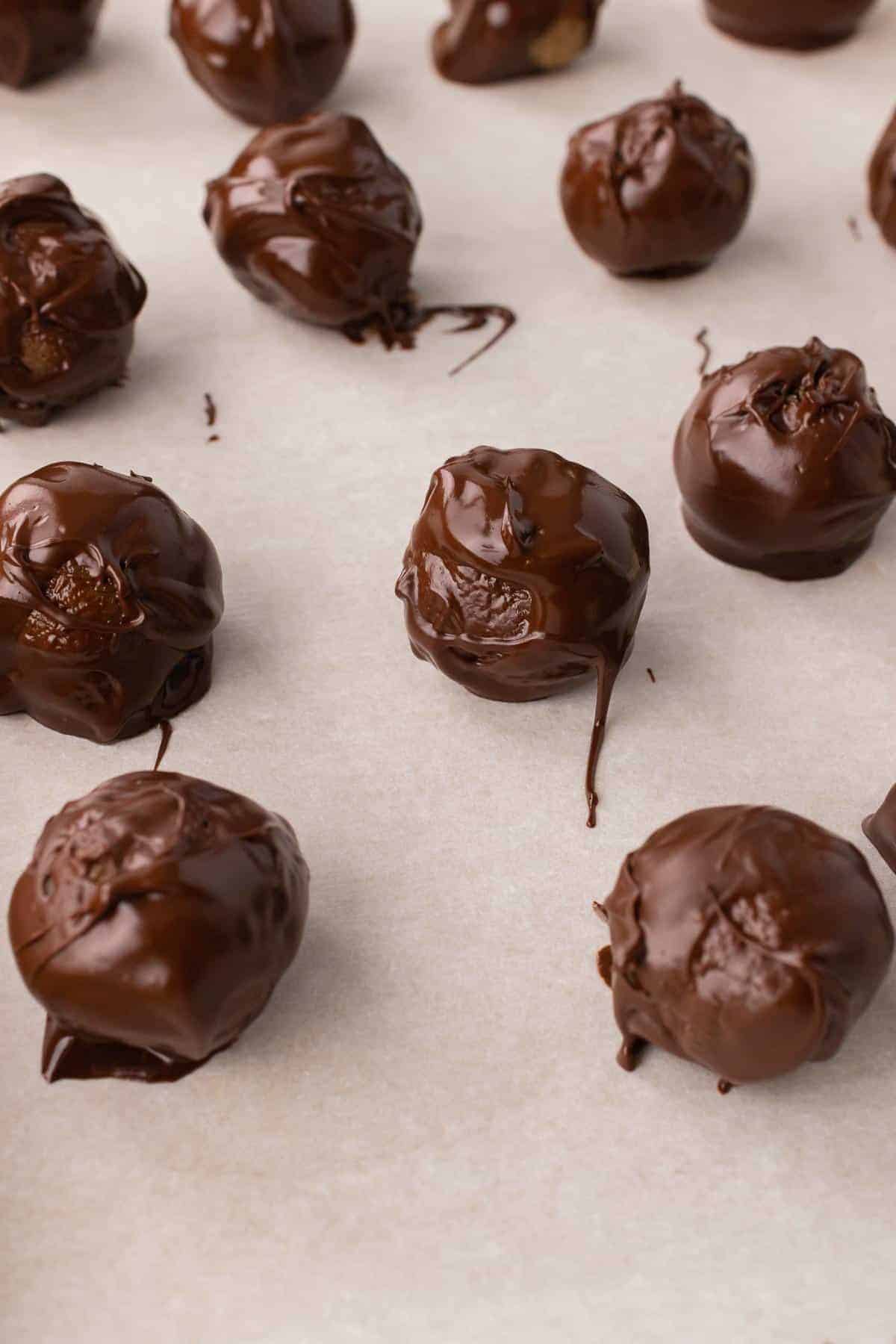 Chocolate covered almond truffles on a cooking sheet