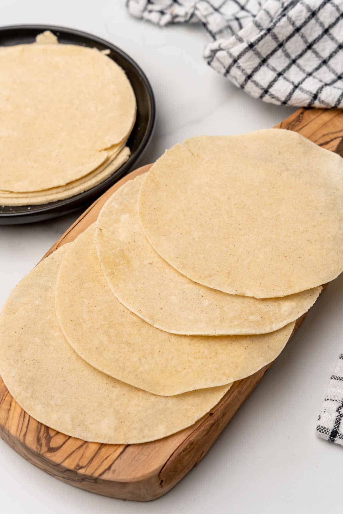 Four Homemade Corn Tortillas on a wooden board