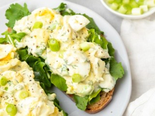 Low sodium egg salad served on two pieces of toast with lettuce on a white plate