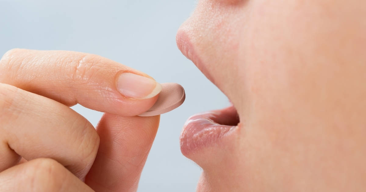 Woman about to take a metformin pill