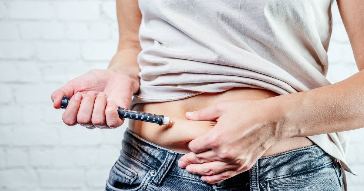 Man injecting insulin in his abdomen with an insulin pen
