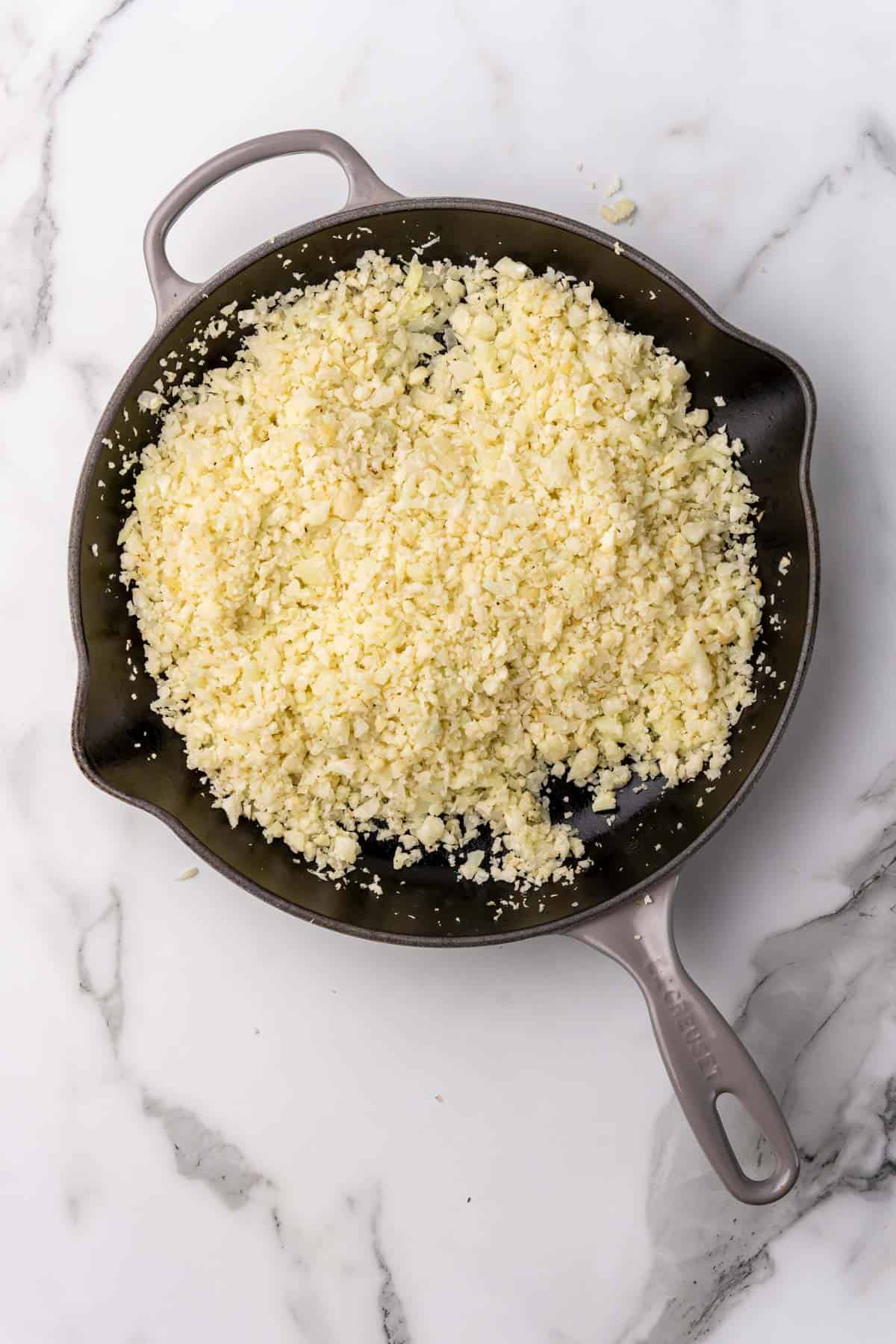 Cauliflower rice cooking in a pan