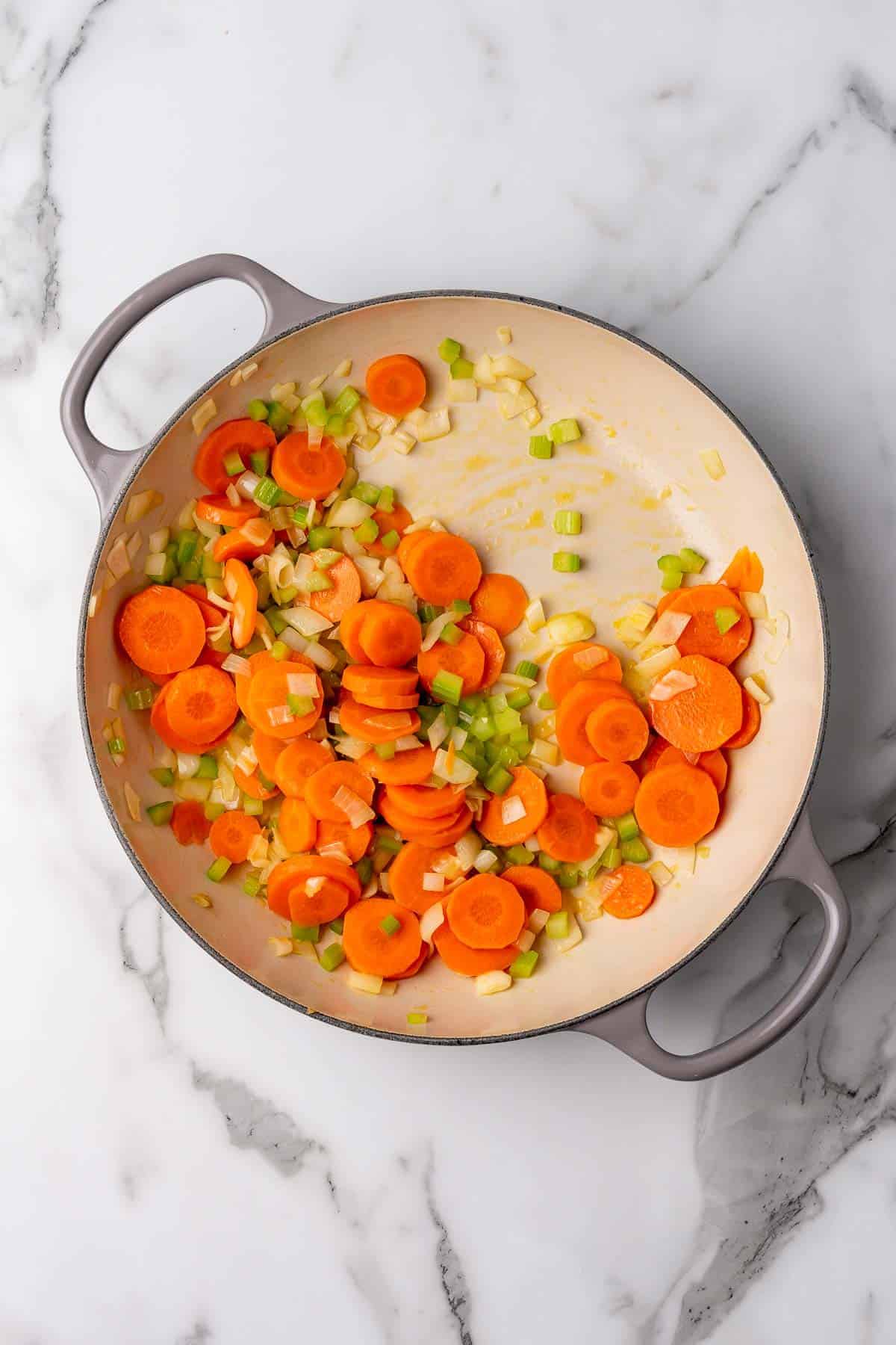 Celery, carrots, and onions browning in a pan