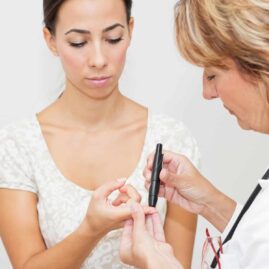 Doctor testing patient for diabetes with a fingerstick test